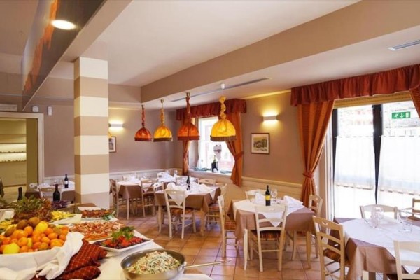 Restaurace s prostřenými stoly, klasickým dekorativním stylem a nabídkou jídel na stolech.