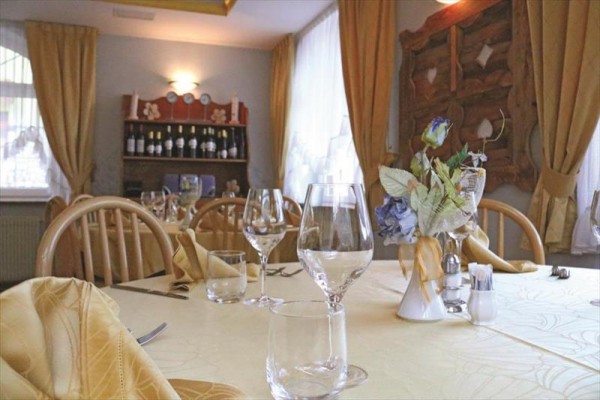 Elegantní jídelní stůl se sklenicemi a květinovou dekorací v útulné restauraci.