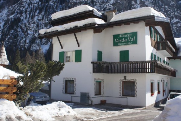 Horský hotel s nápisem „Albergo Verda Val Ristorante“ pokrytý sněhem.