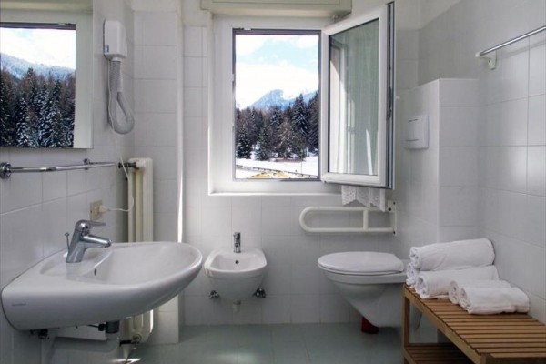 Koupelna s umyvadlem, WC a bidetem, výhled z okna na zasněžené hory.