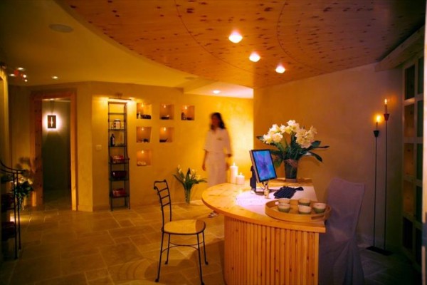 Interiér wellness centra s recepcí a květinami na pultu.