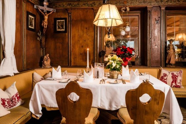 U stolu v rustikální restauraci je svátečně prostřeno s květinami a svíčkou.