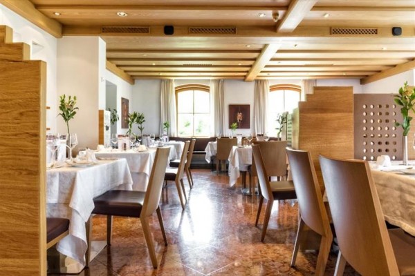 Elegantní restaurace s dřevěným interiérem a prostřenými stoly.  