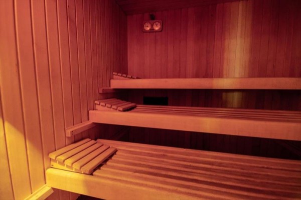 Dřevěná sauna se třemi lavicemi.