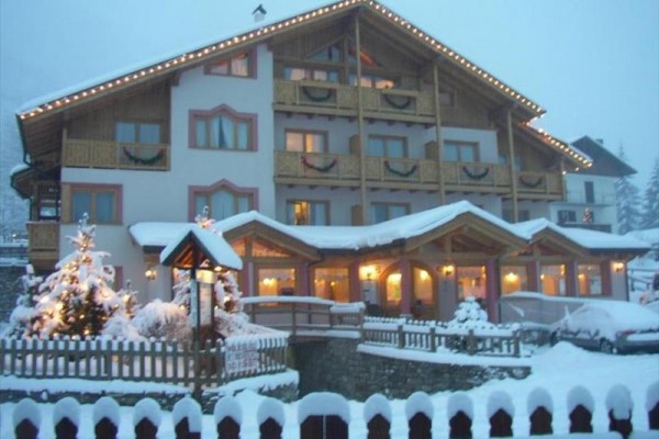 Horský hotel se světly a zasněženou krajinou.