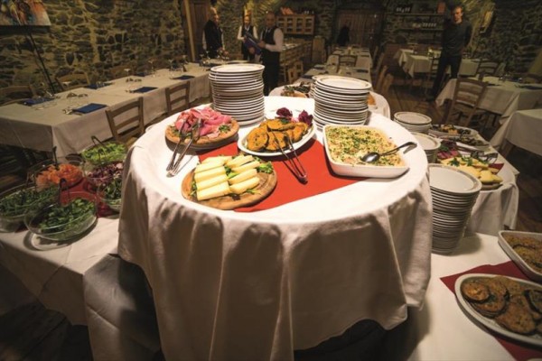 Stolní bufet s různými pokrmy připravený k podávání v restauraci.