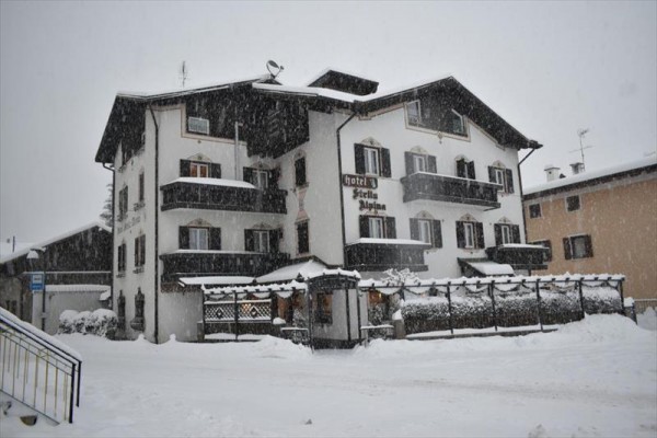Budova hotelu zasněžená během sněžení.