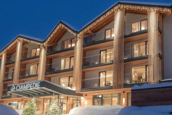 Hotel ve večerním osvětlení se zasněženou krajinou.