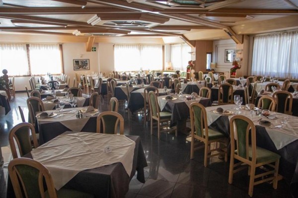 Restaurace s prostřenými stoly a dřevěnými židlemi.
