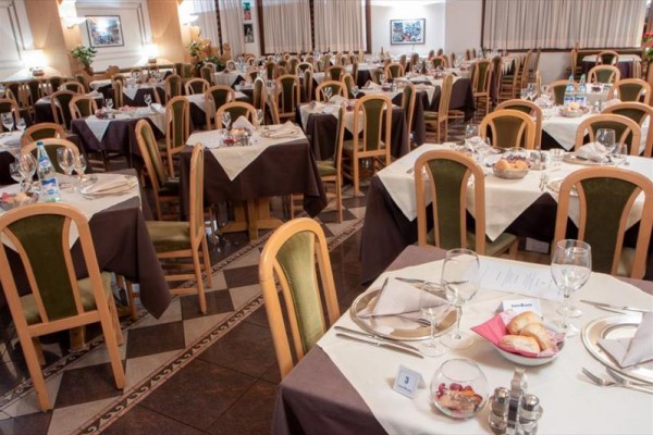 Restaurace s mnoha stoly prostřenými k večeři.