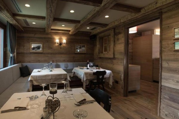 Restaurace s dřevěnými stěnami a prostřenými stoly.