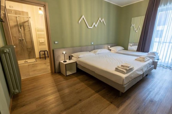 Moderní hotelový pokoj s dvěma lůžky a koupelnou.