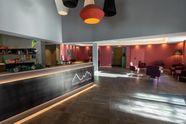 Recepce hotelu s moderním osvětlením a sedacími soupravami.