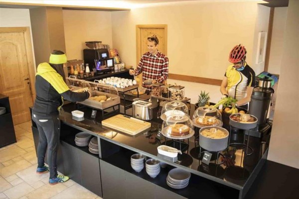Lidé si vybírají jídlo ze snídaňového bufetu v hotelu.
