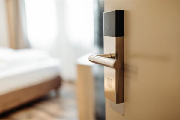 Dveře s elektronickou klikou vedoucí do světlého pokoje.