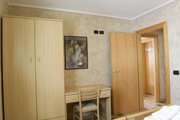 Horská chata s dřevěnými balkony a solárními panely na střeše.