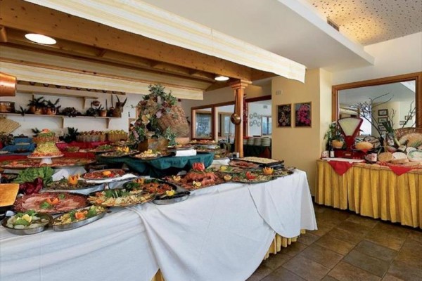 Rautový stůl plný různorodých pokrmů a pochutin v restauraci.
