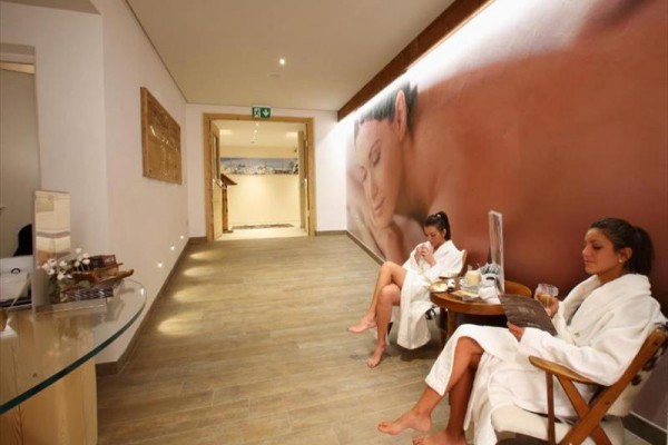 Dvě ženy v županech relaxují v lázeňské čekárně.