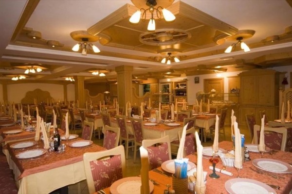 Elegantně prostřená restaurace s dřevěným nábytkem a stropní výzdobou.
