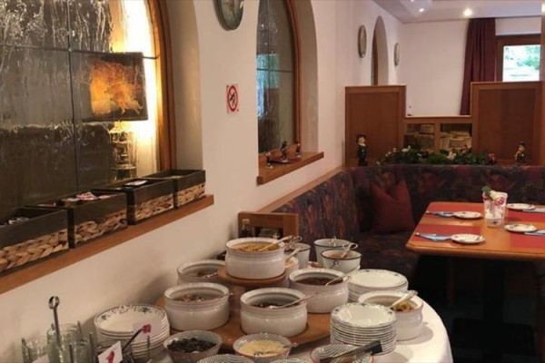 Bufetový stůl s hrnci a mísami v restauraci s rustikálním interiérem.