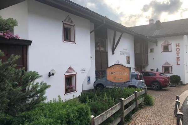 Budova hotelu s parkovištěm a nápisem 