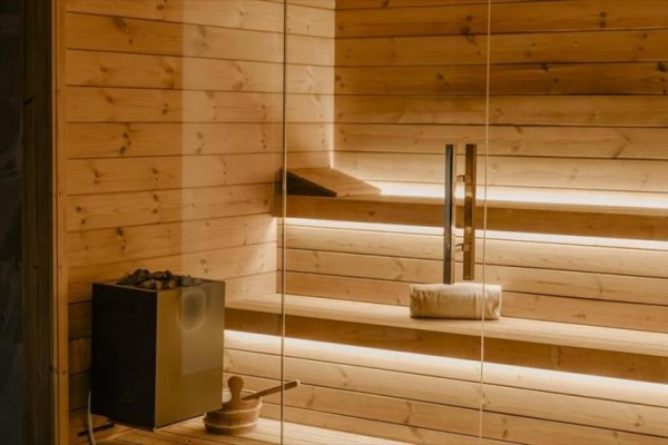 Dřevěná sauna s lavicí a osvětlením.