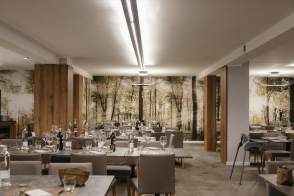 Moderní restaurace s dřevěným dekorem a stoly přichystanými pro hosty.