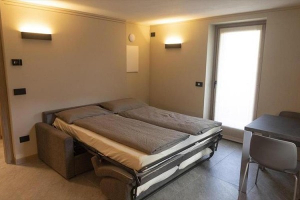 Rozkládací pohovka s dvojlůžkem v moderní světlé místnosti.