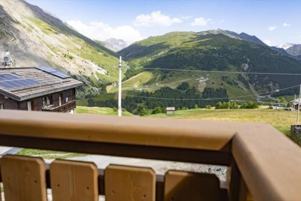 Moderní umyvadlo na dřevěné skříňce s černou deskou a ručníkem.