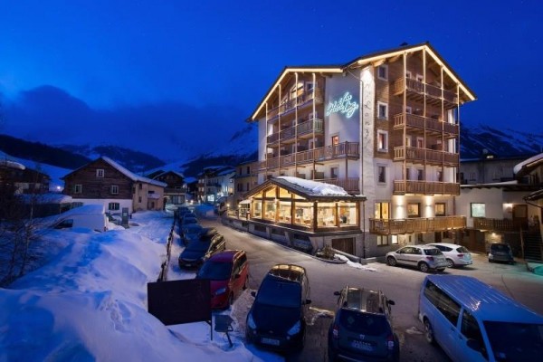 Hotel s osvětlením ve večerní horské vesnici.