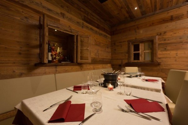 Stylový dřevěný interiér restaurace s připraveným stolem na fondue.